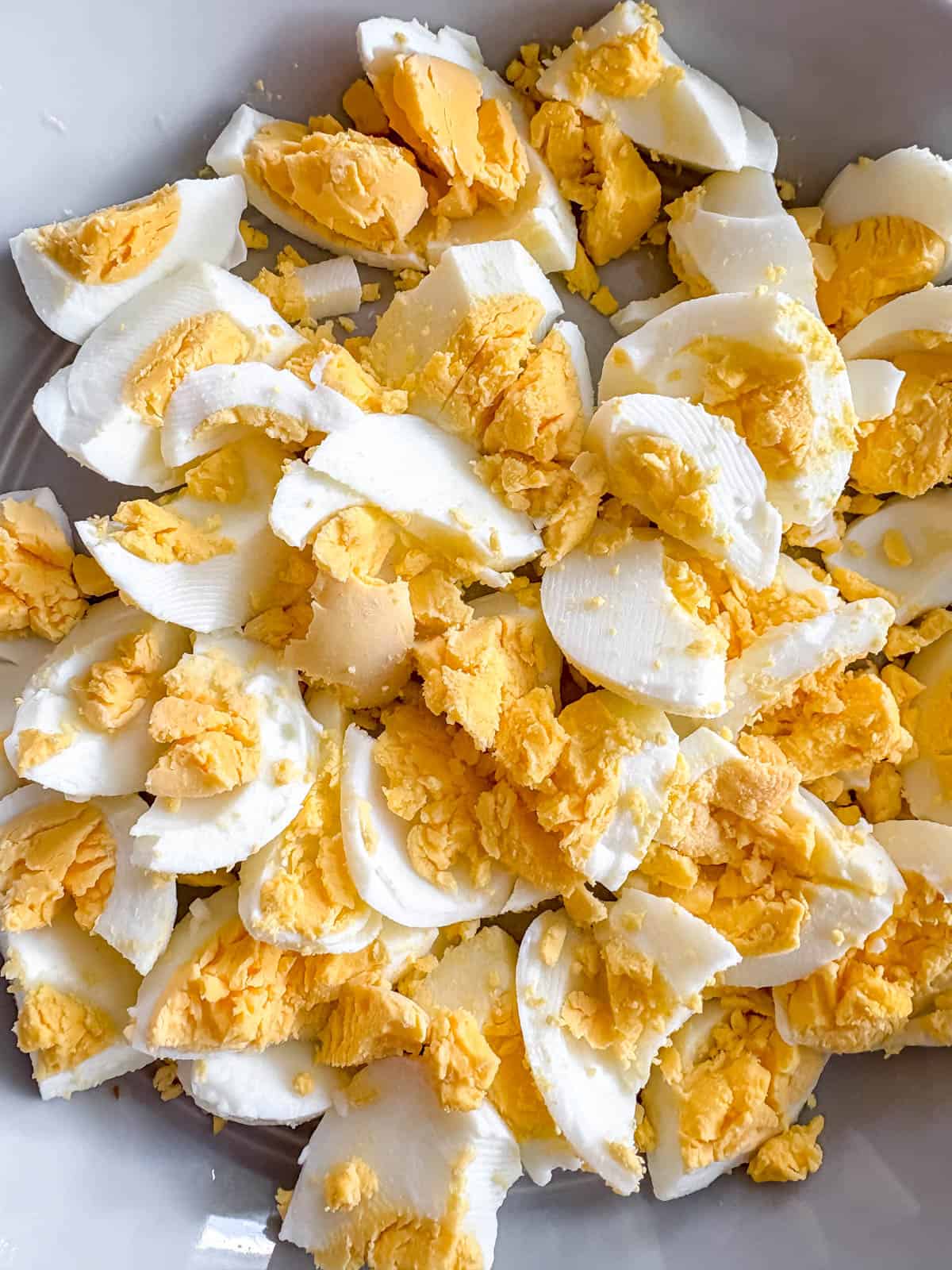 Hard boiled eggs cut up in a bowl.