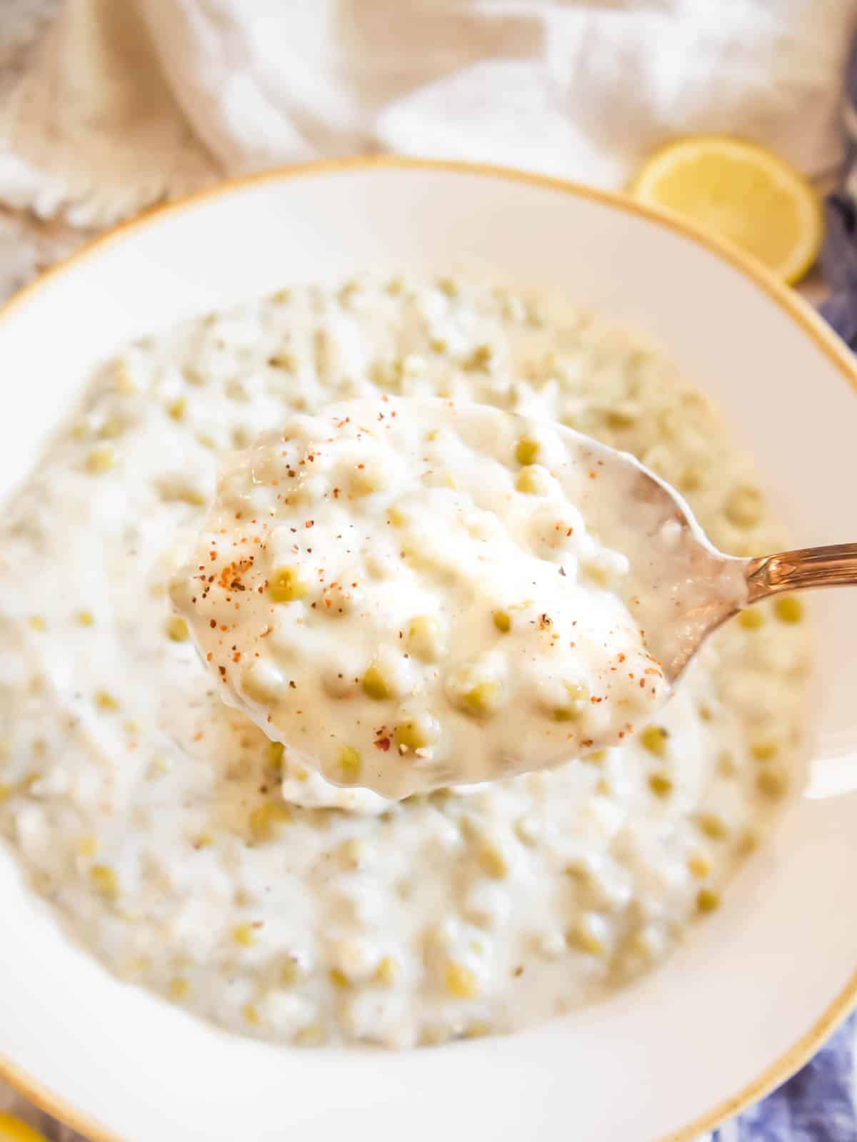 A spoon scooping up creamed peas.