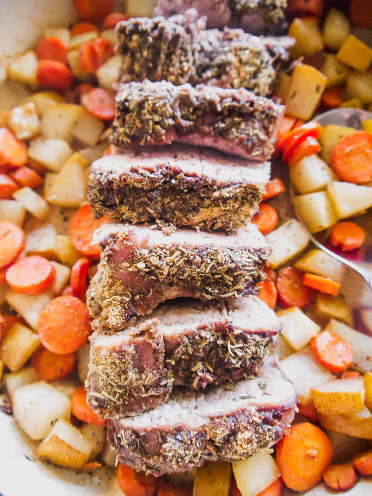 Sliced Pork Loin in a dutch oven with pears and carrots.