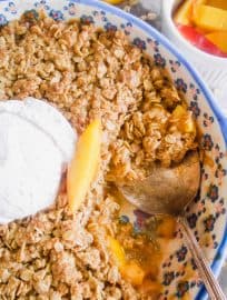 Nectarine Crisp in a baking dish with a spoon in it.