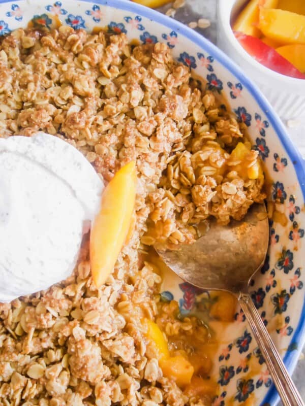Nectarine Crisp in a baking dish with a spoon in it.