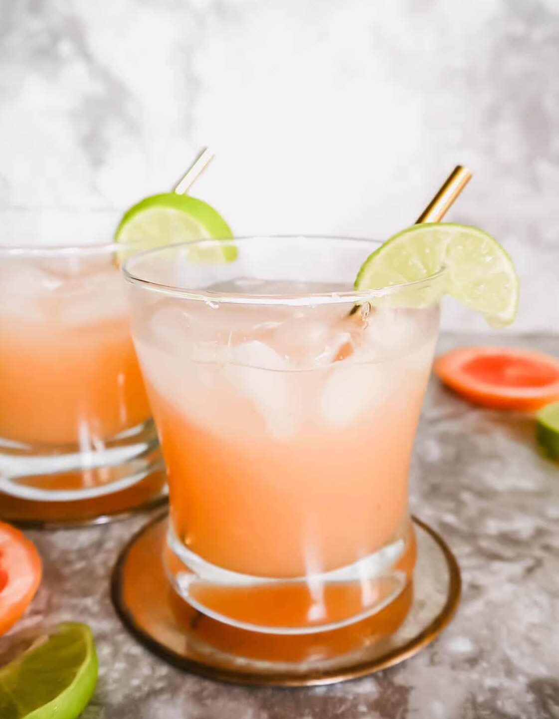 Healthy paloma recipe in two glasses with a lime on the rim.