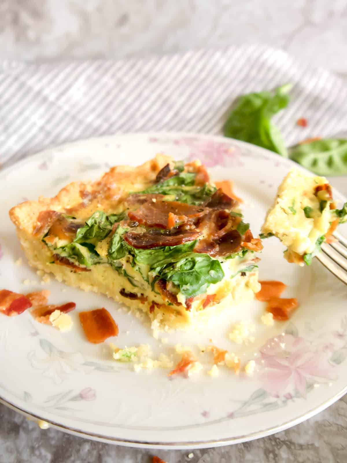 A slice of Paleo Gluten-free Spinach Bacon Quiche.