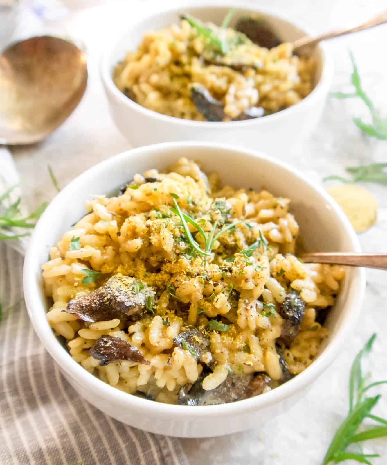 Dairy-Free Mushroom Risotto in two bowls with spoons in them.