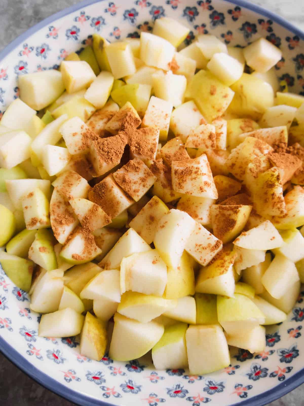 Apples and seasoning in a baking dish prior to baking.