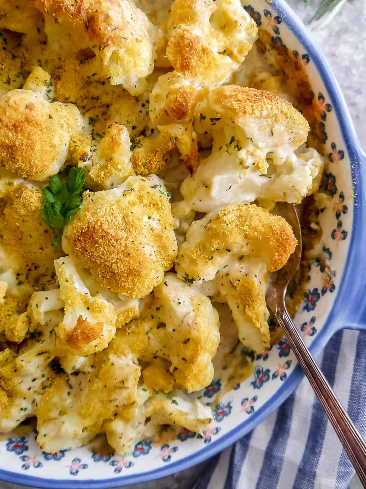 Vegan cauliflower gratin freshly baked with a spoon in it.