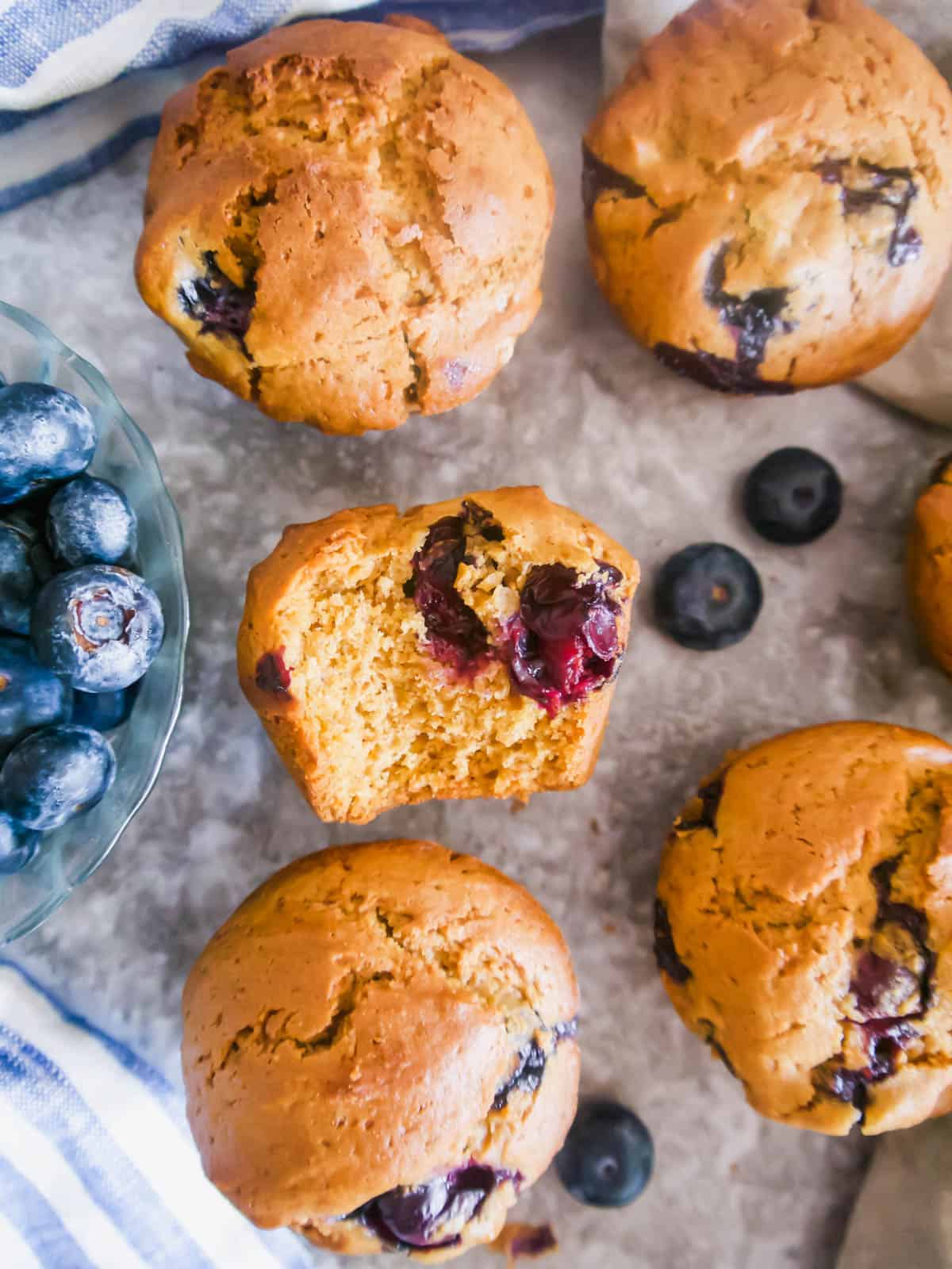 A bite taken out of a Dairy-free Blueberry Muffins made with with Olive Oil.
