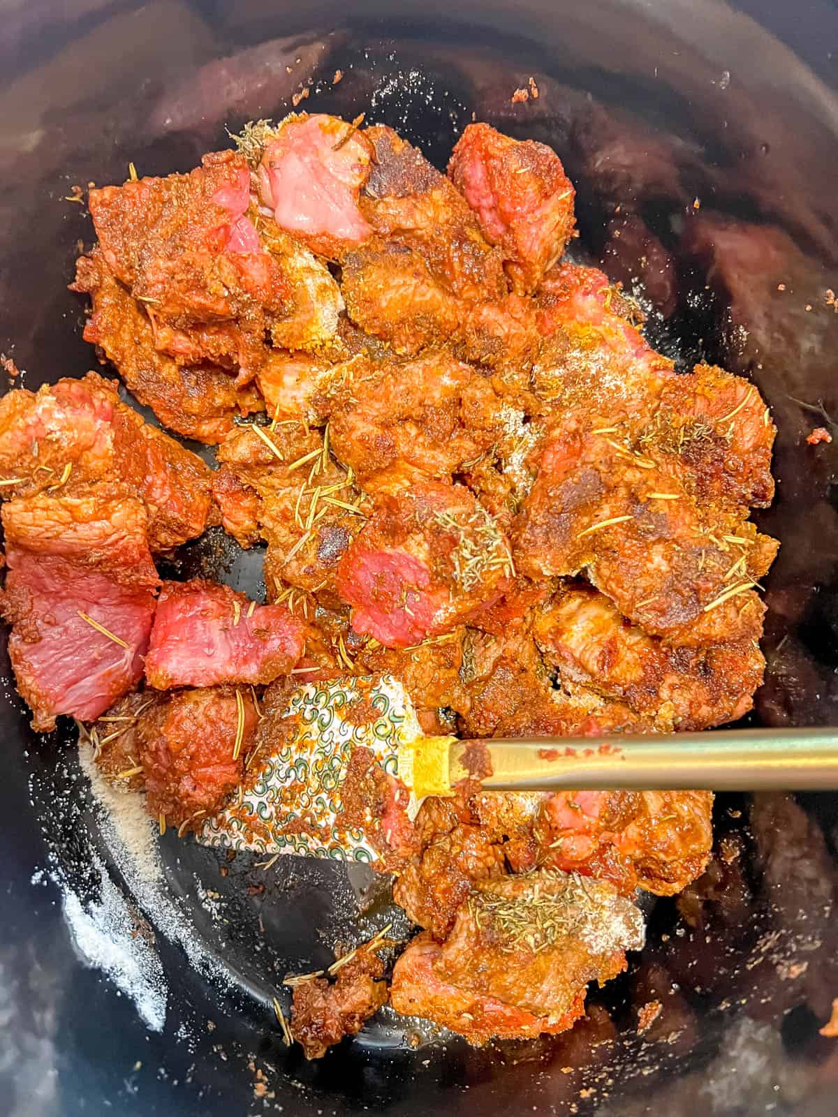 Seared meat in crockpot with coconut flour on top.