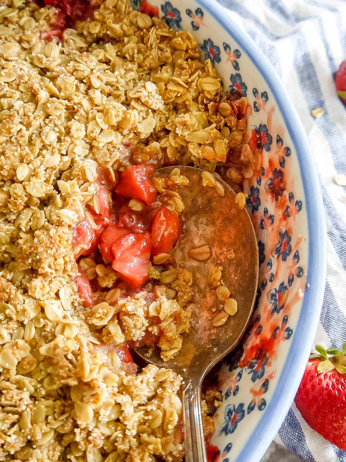 A large spoon filled with gluten-free strawberry crisp.