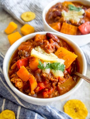 Butternut Squash Turkey Chili in a bowl with cheese on top.