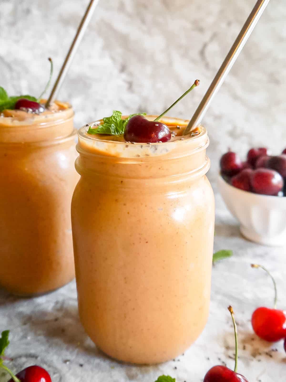 Mango carrot yogurt smoothie in two mason jars.