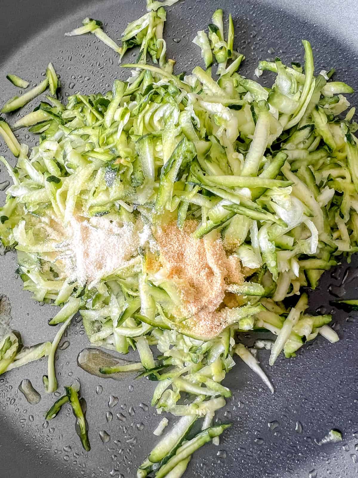Shredded zucchini in a pan with spices.