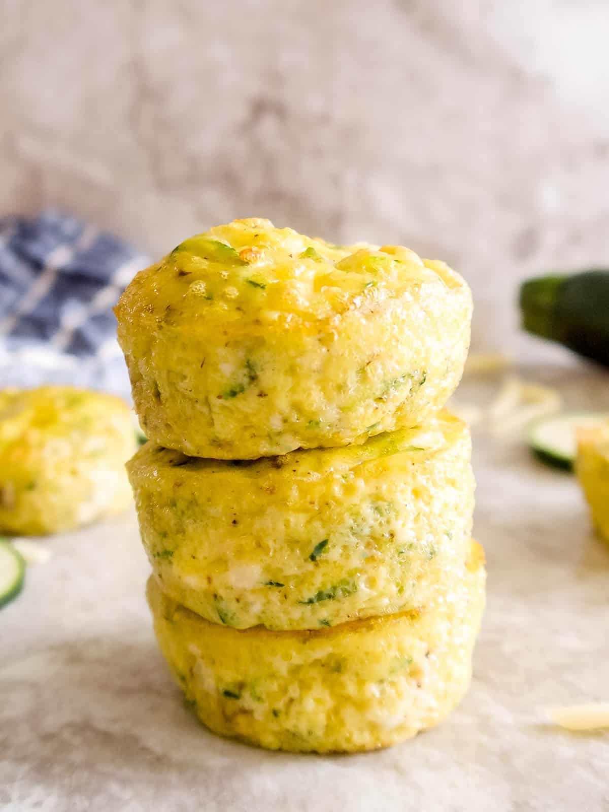 Zucchini egg muffins stacked on top of each other.