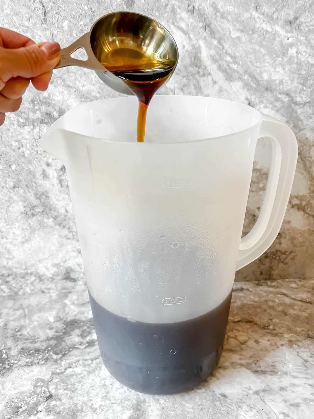 Maple syrup being added to sweet tea.