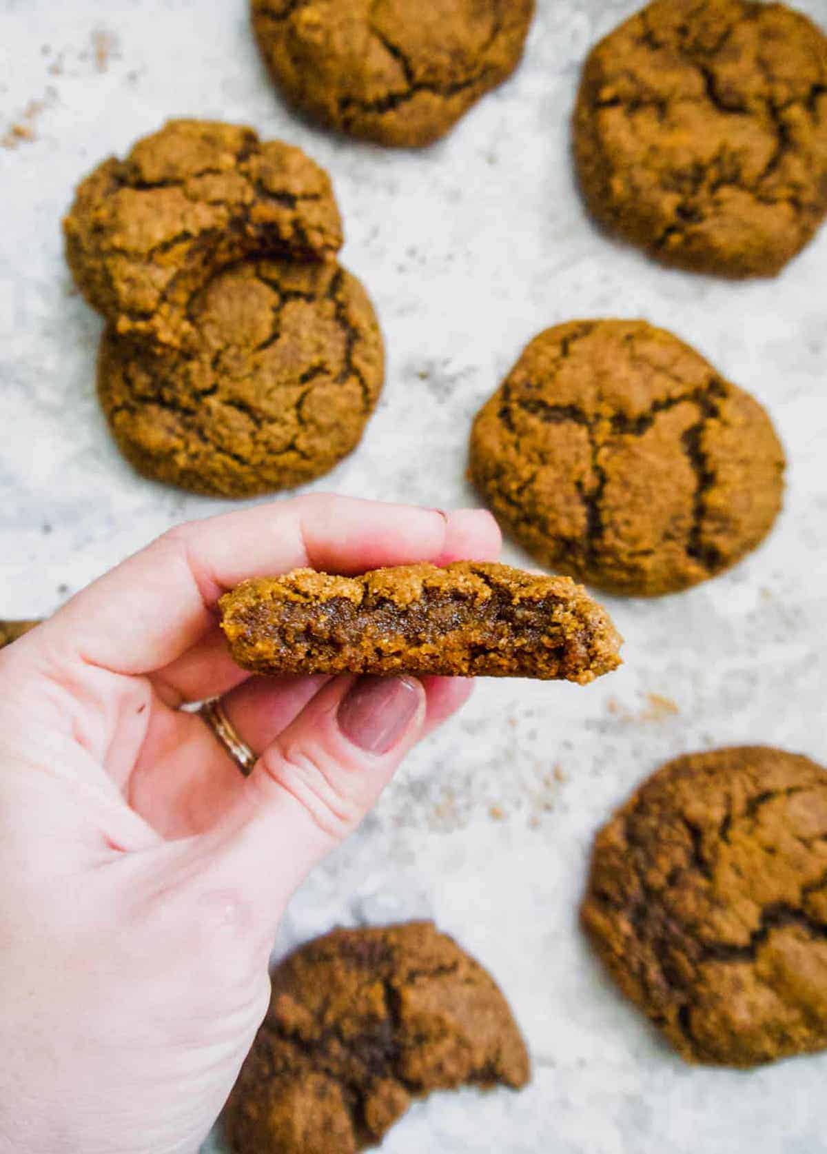 Molasses almond flour cookies with a bite taken out of one.