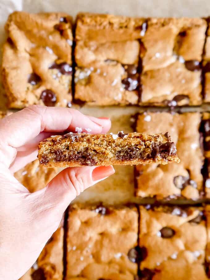 gluten-free chocolate chip cookie bars in hand about to be bitten