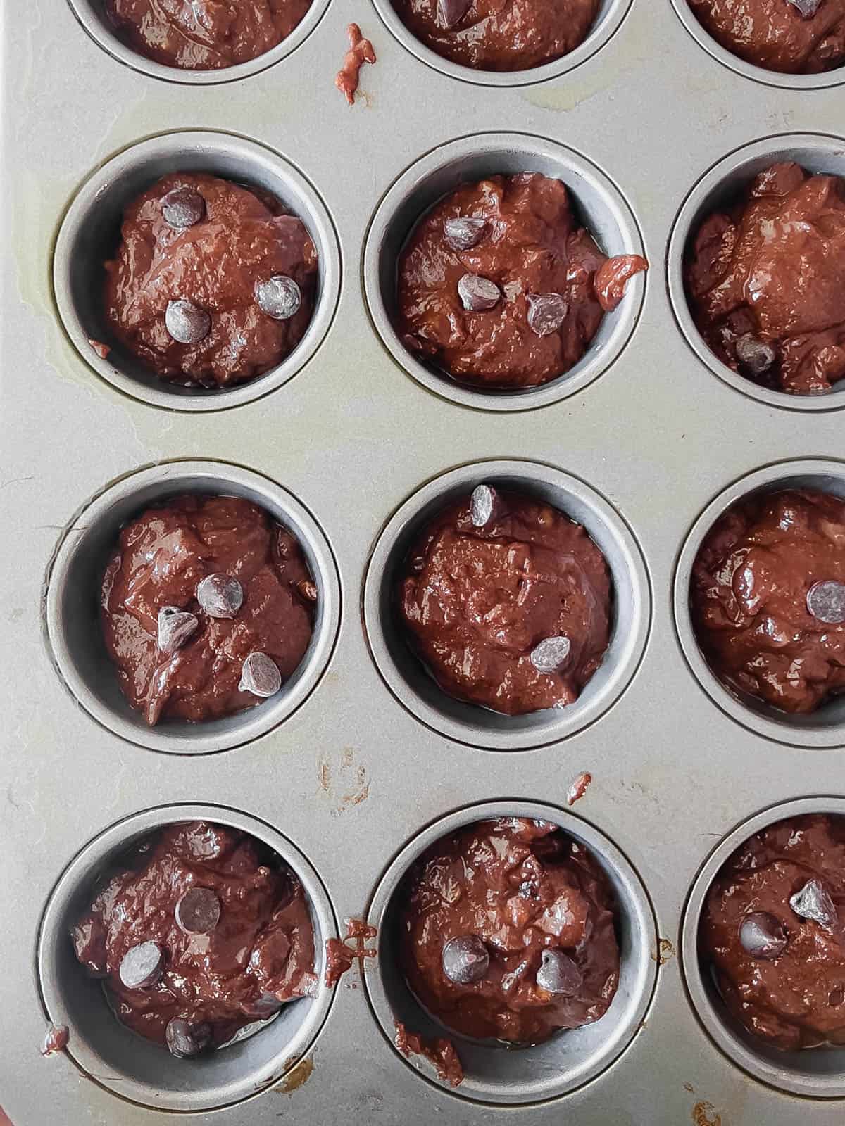 Paleo chocolate muffin batter in muffin tins before baking.