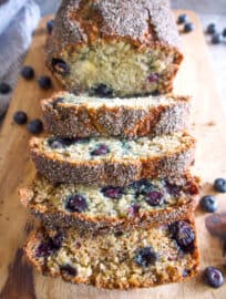 Slices of Healthy Blueberry Banana Bread with Chia Seeds on a cutting board.