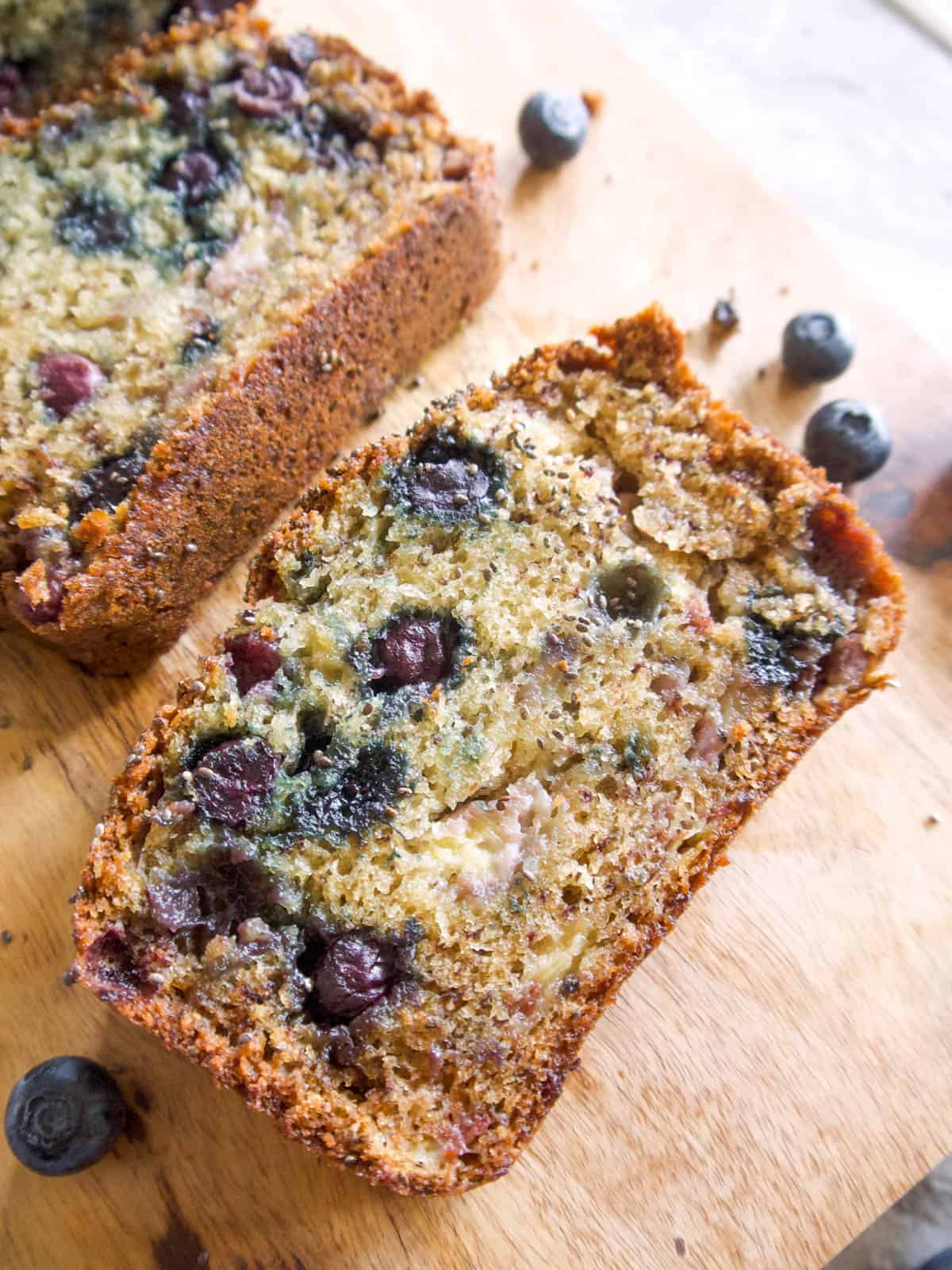 One slice of healthy banana blueberry bread on a table.