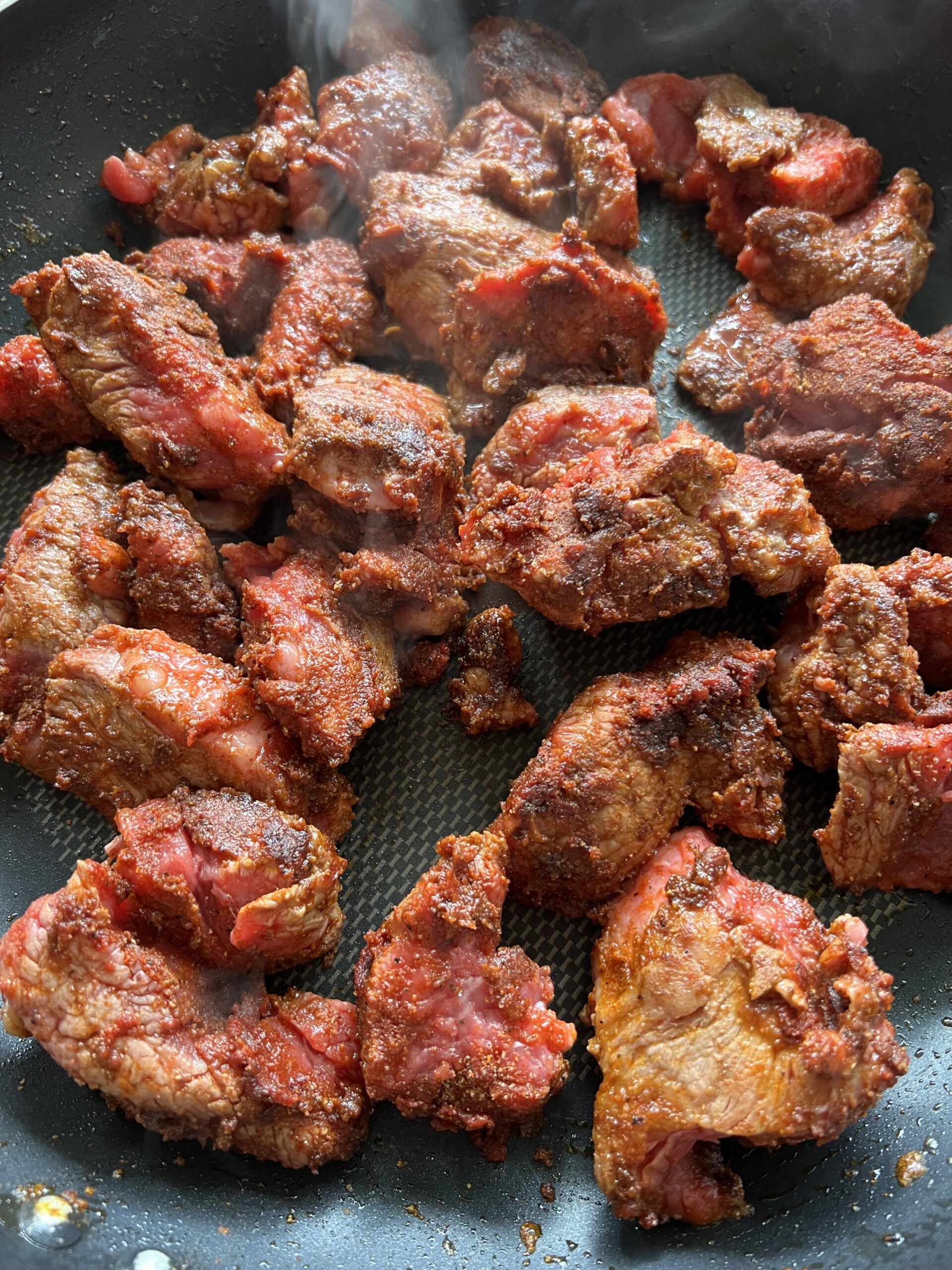 Seared meat in frying pan.