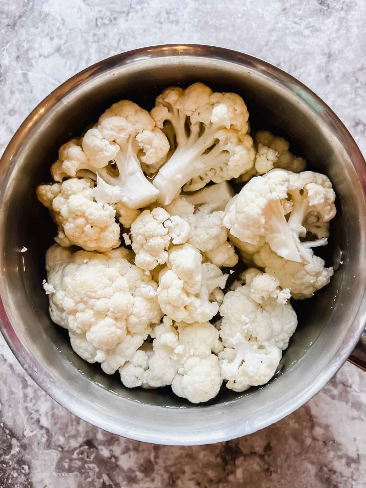 Cauliflower in a pot, ready to be boiled.