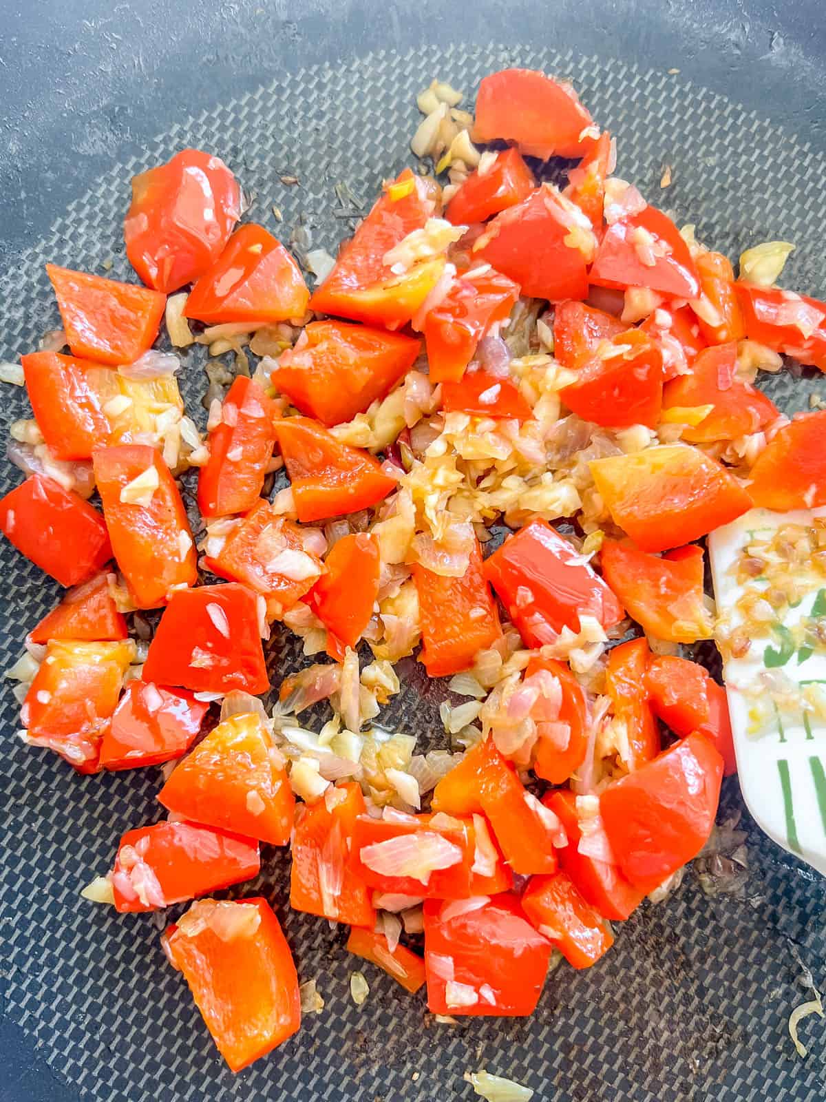 Red pepper, garlic and onion in frying pan.