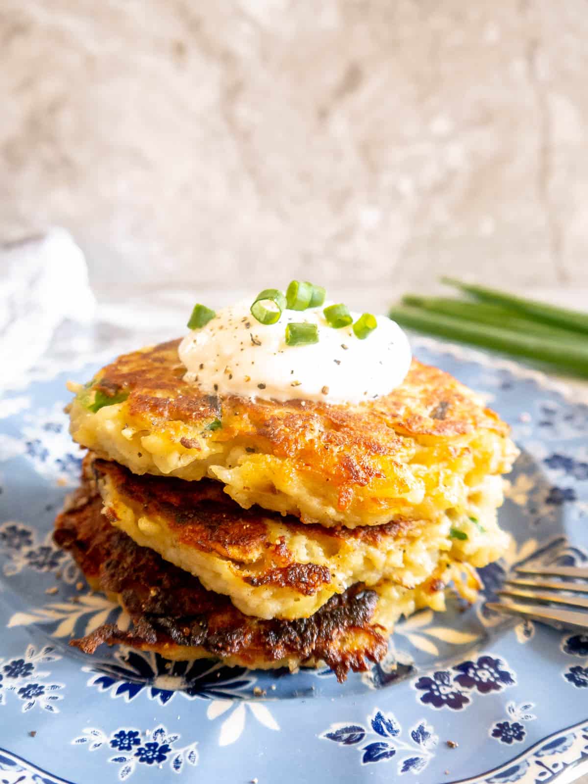 Whole30 potato pancakes on a plate, stacked on top of each other.