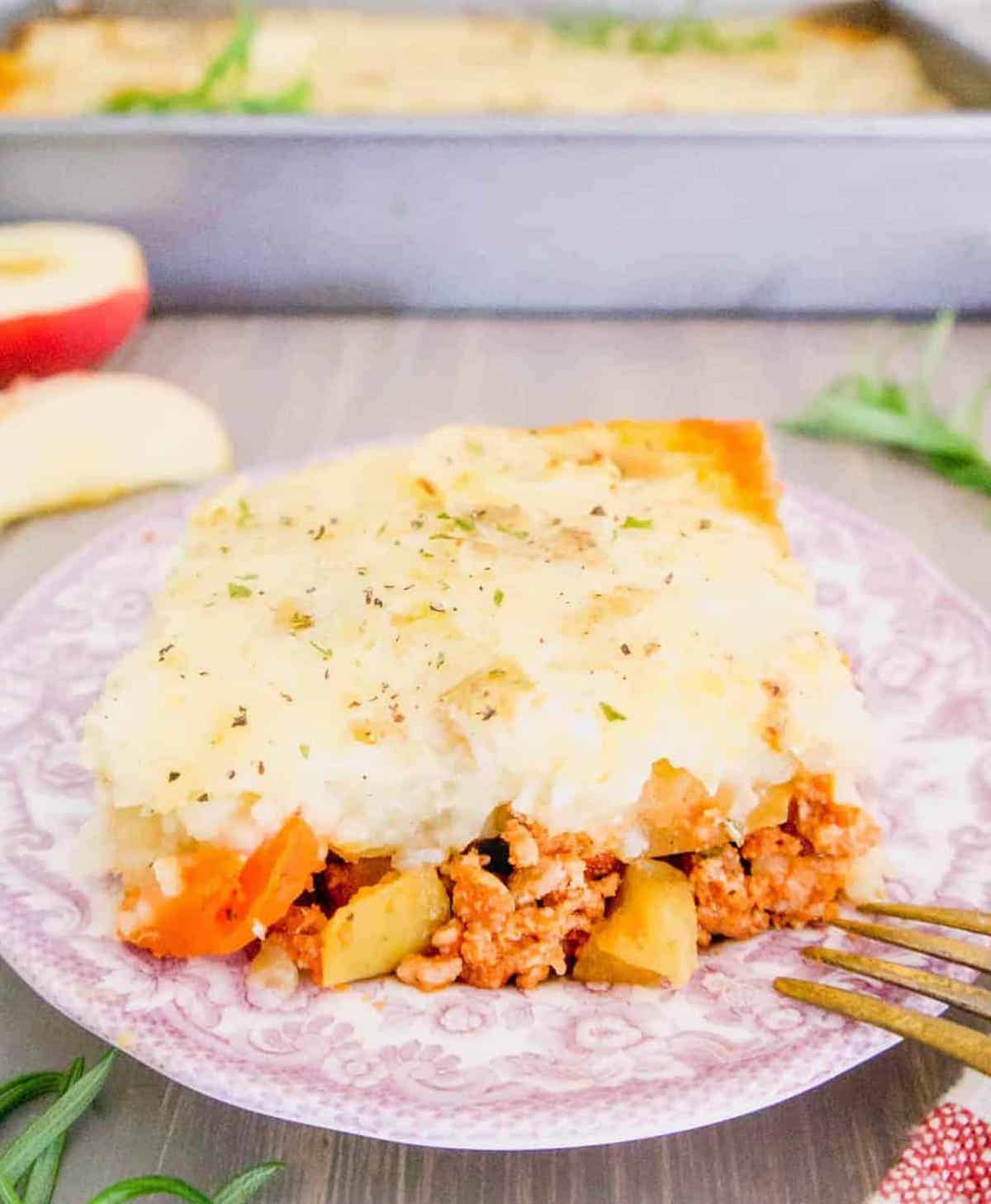 A slice of healthy shepherd's pie with ground turkey and apples on a plate.