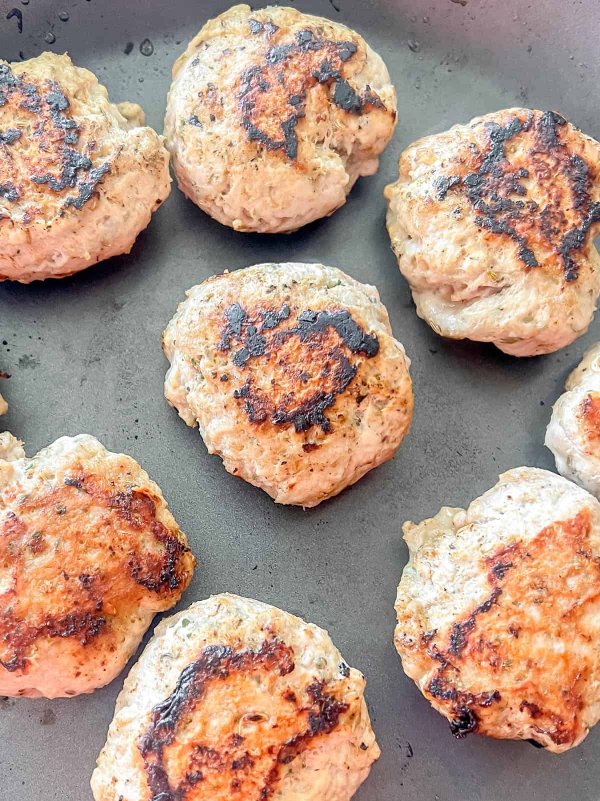 Turkey sausage patties in a pan after cooking.
