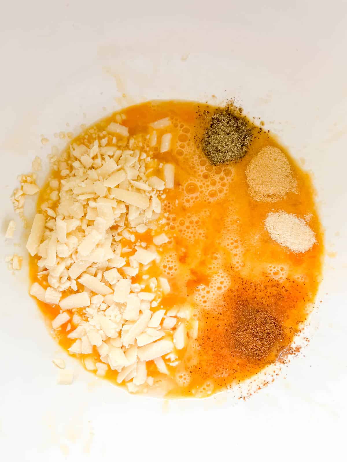 Spices added to eggs in a bowl.