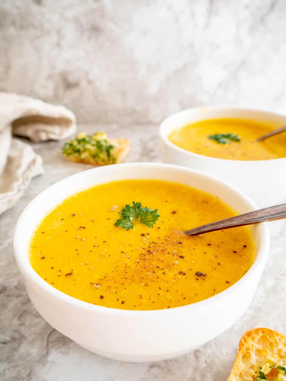 High protein butternut squash soup in a bowl with a spoon.