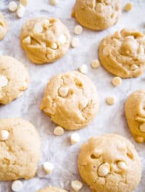 White chocolate chip cookies surrounded by white chocolate chips.