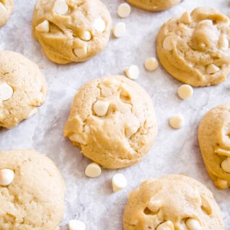 White chocolate chip cookies surrounded by white chocolate chips.