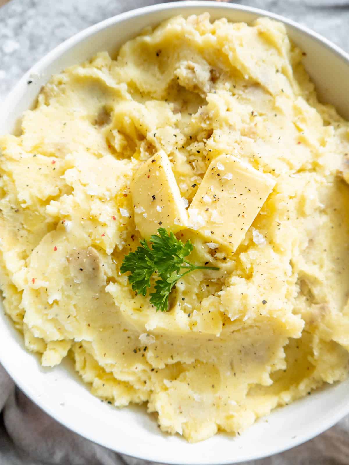 Cottage cheese mashed potatoes in a bowl with butter on top.