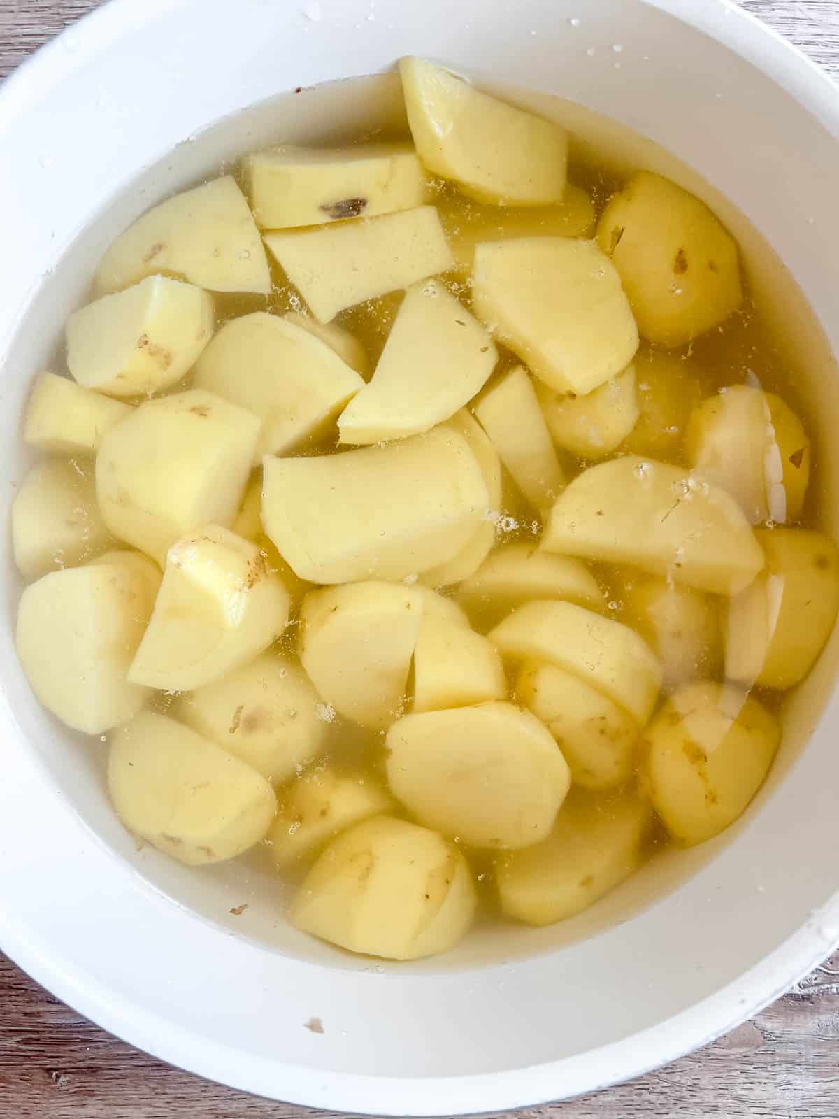 Potatoes in a large pot of hot water.