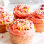Small Batch Strawberry Cupcakes on a plate with frosting and sprinkles on top.