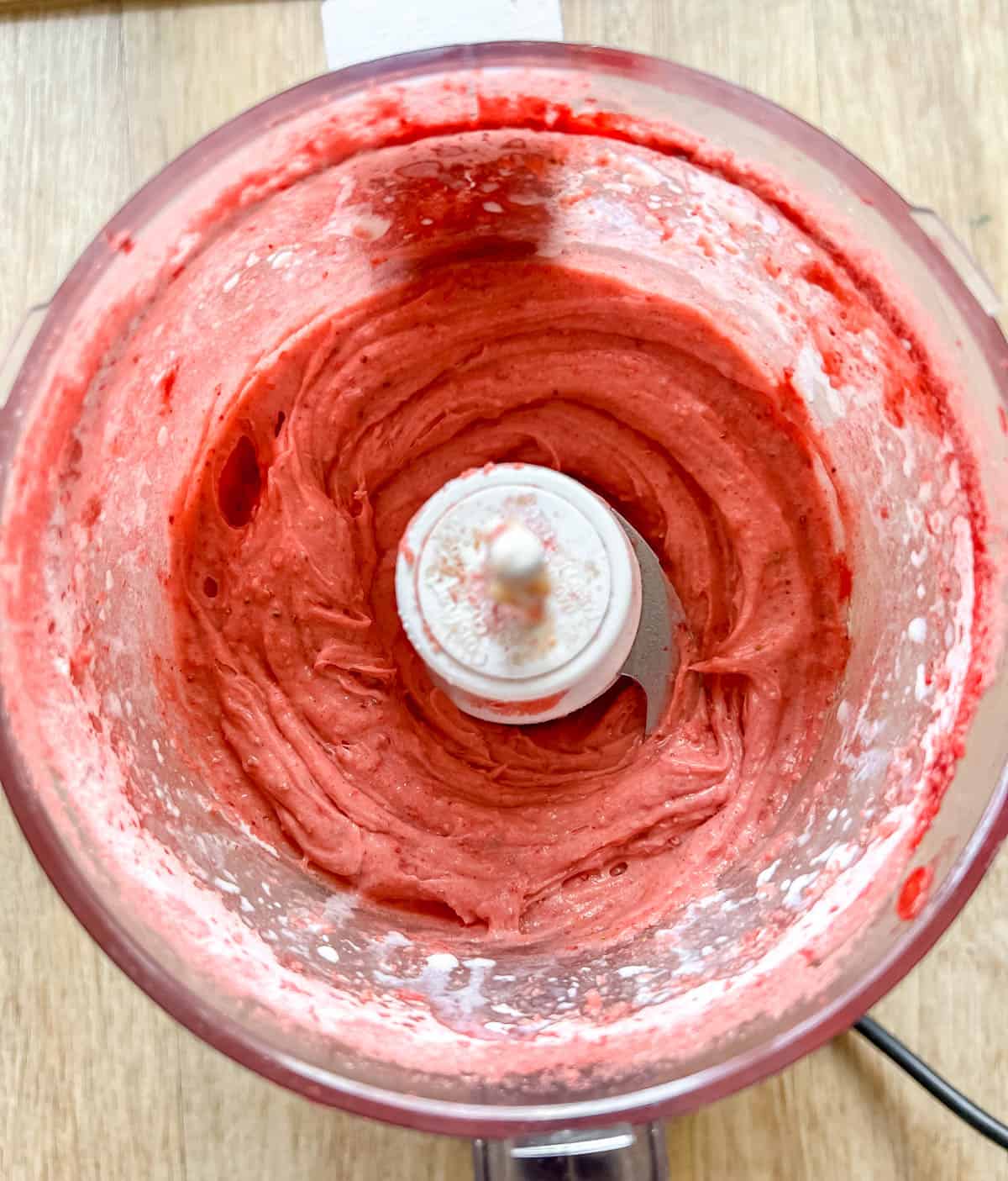 Strawberry frosting in a food processor.