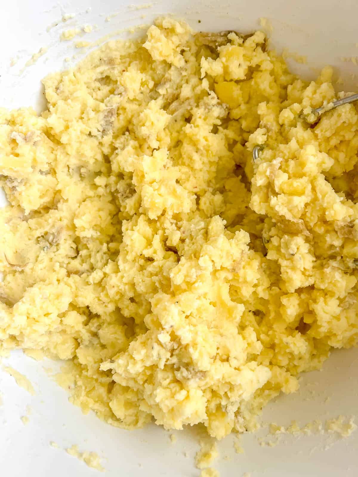 Greek yogurt in mashed potatoes in a bowl.