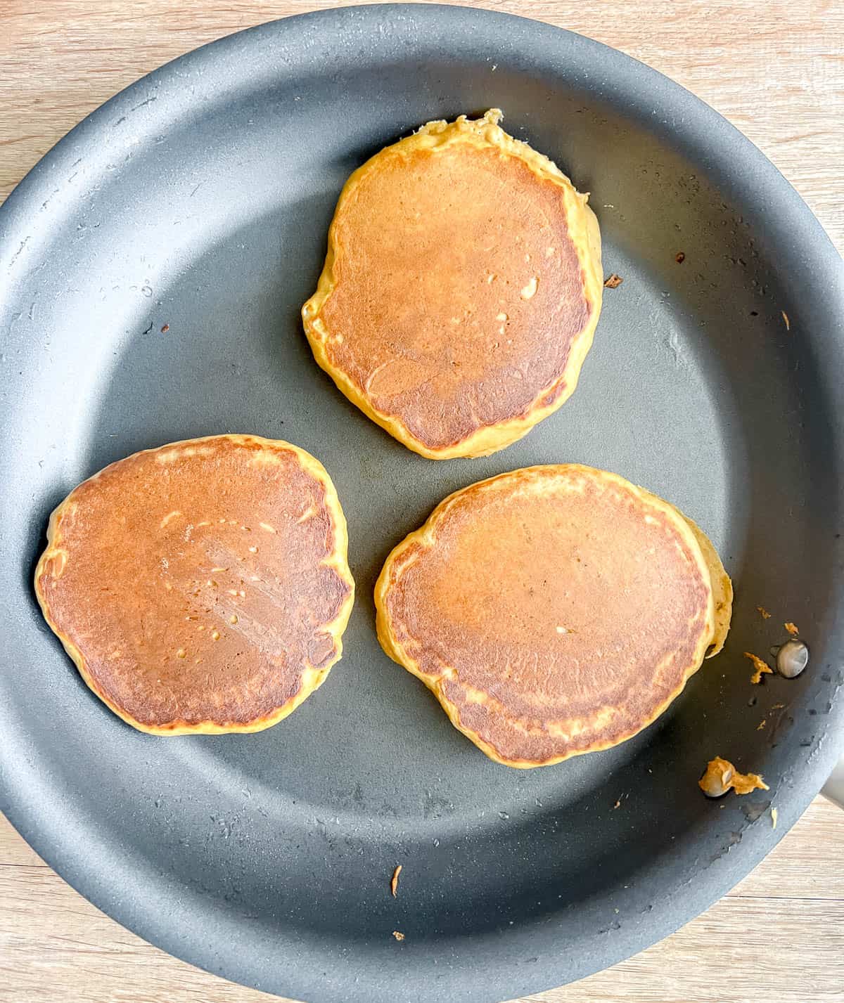 Healthy pumpkin pancakes flipped on a pan.