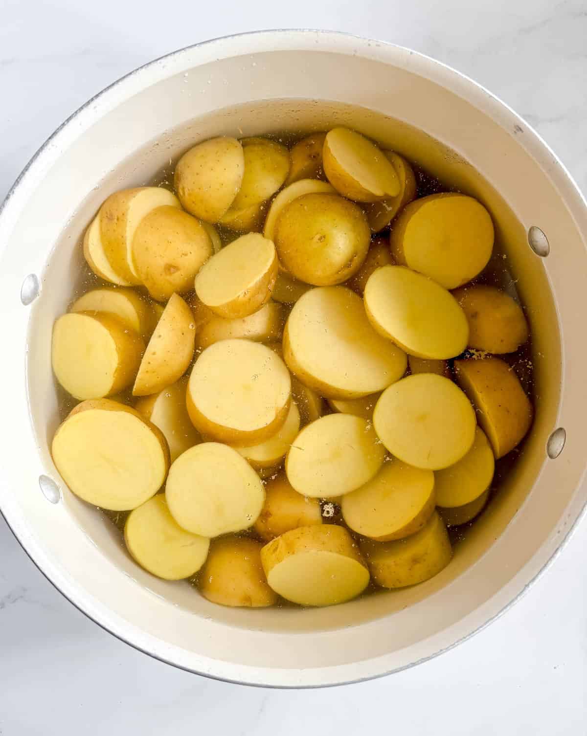 Potatoes in water preparing to boil.