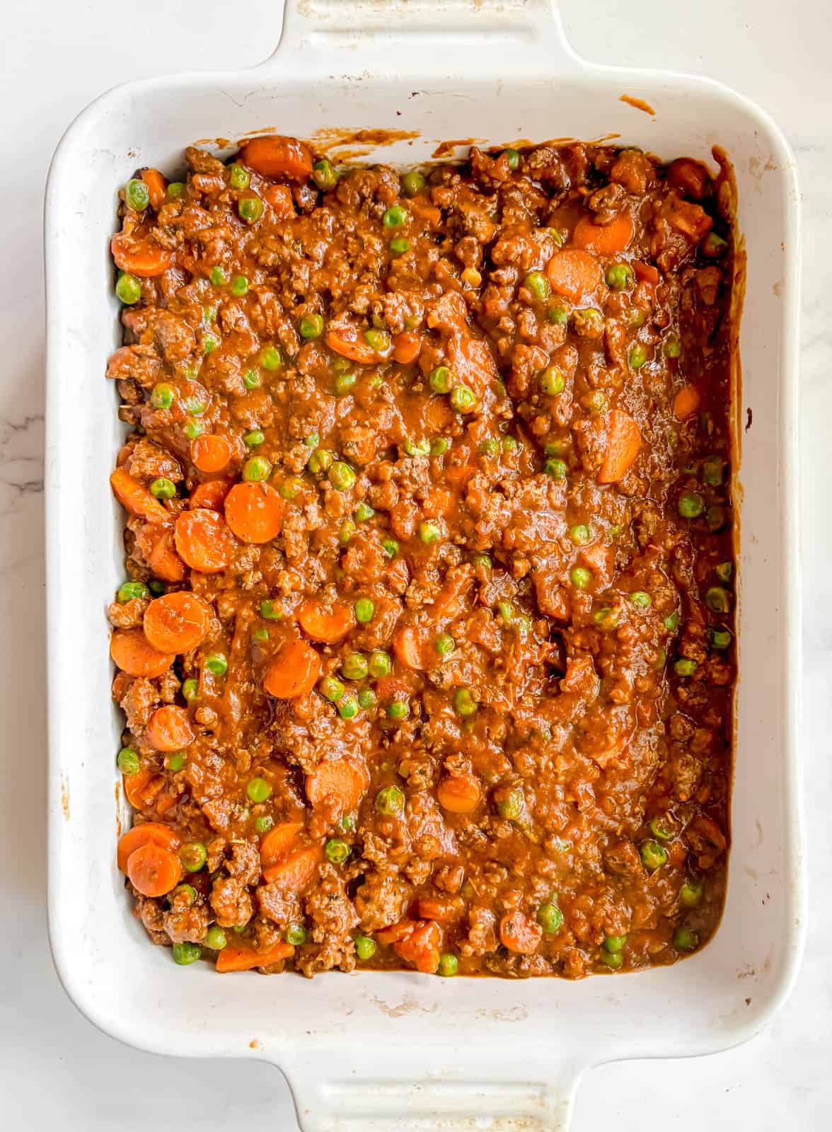 Ground beef shepherd's pie filling added to a pan.