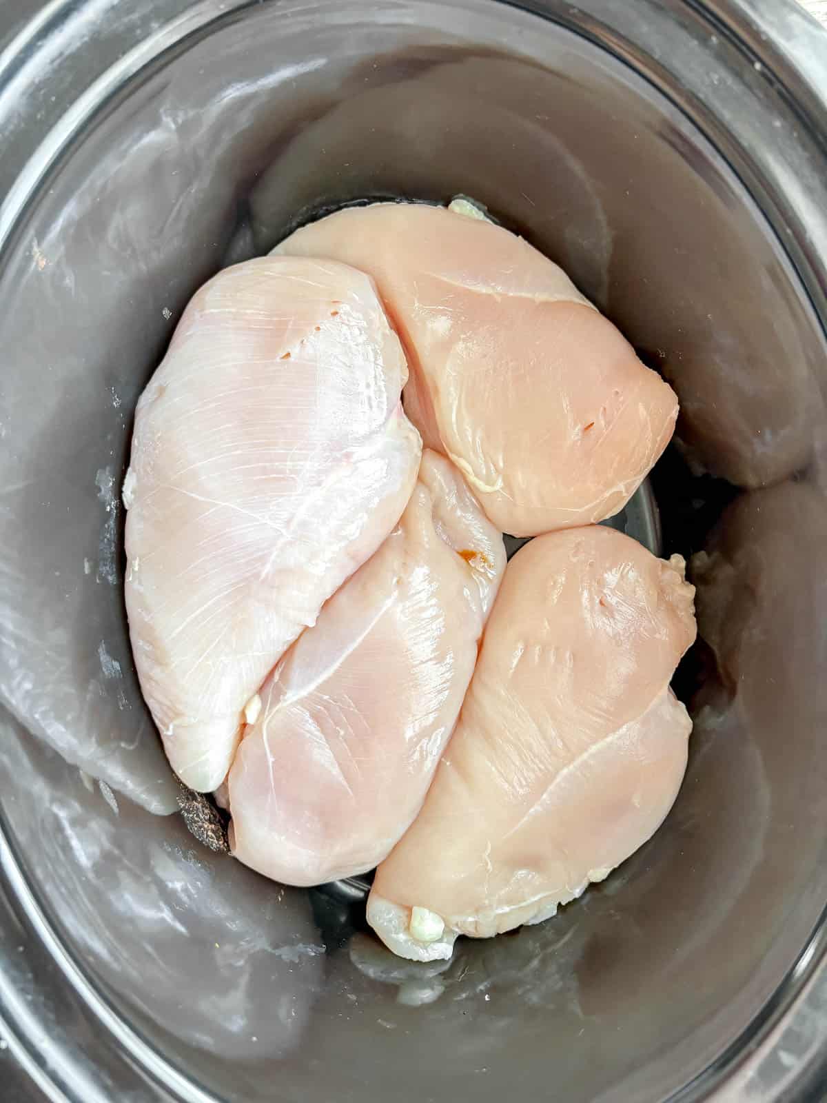 Chicken breast in a slow cooker before cooking.