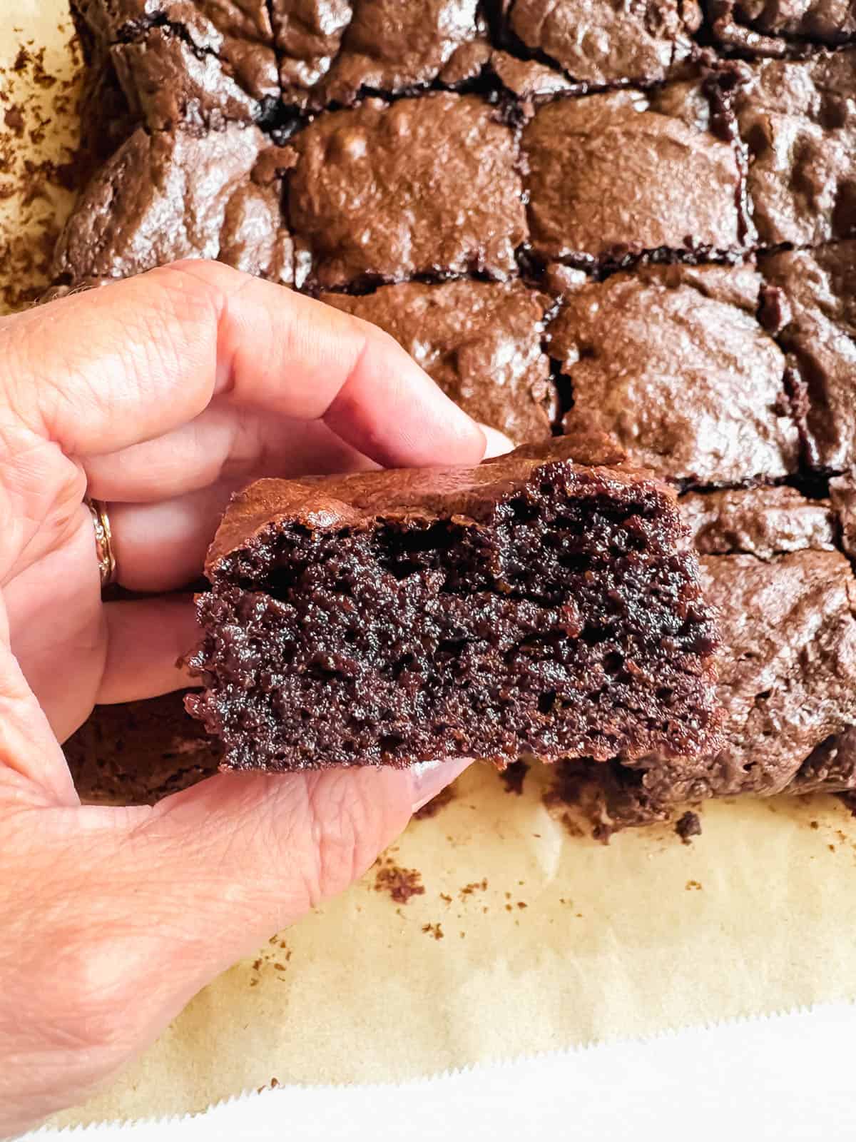 A slice of olive oil brownie in one's hands.