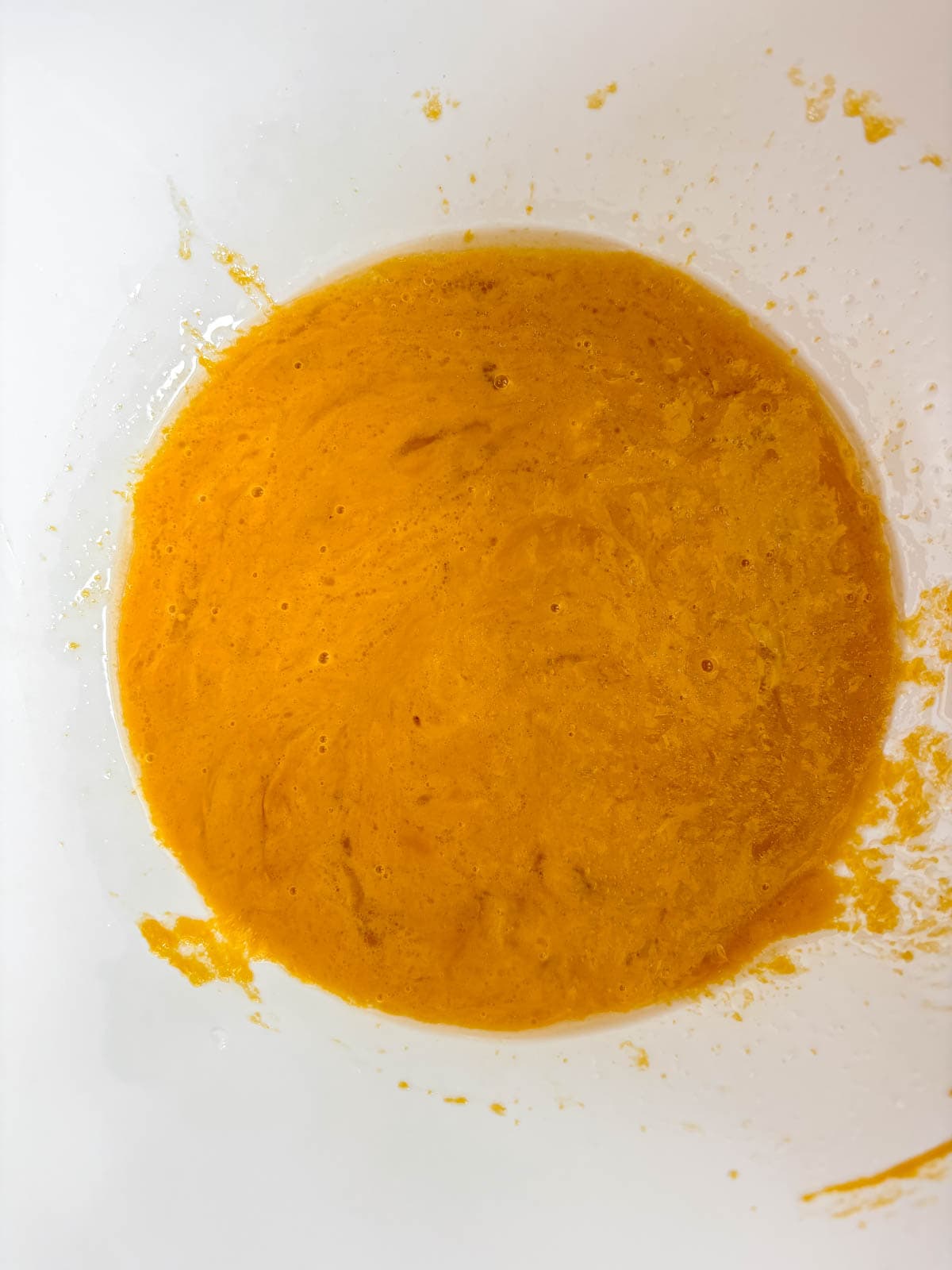 Wet ingredients in a bowl for healthy pumpkin muffin recipe.