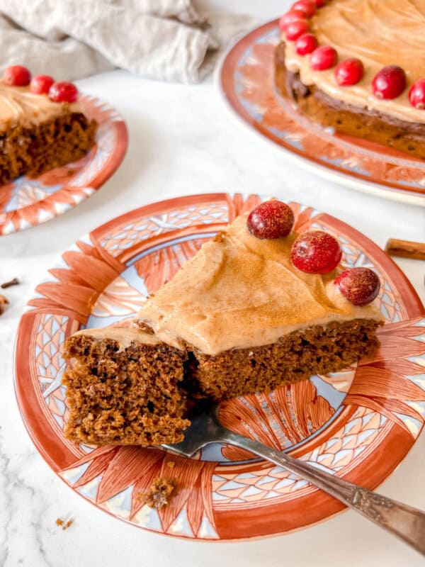 A slice of Gingerbread Cake with Cinnamon Cream Cheese with a fork cutting into it.