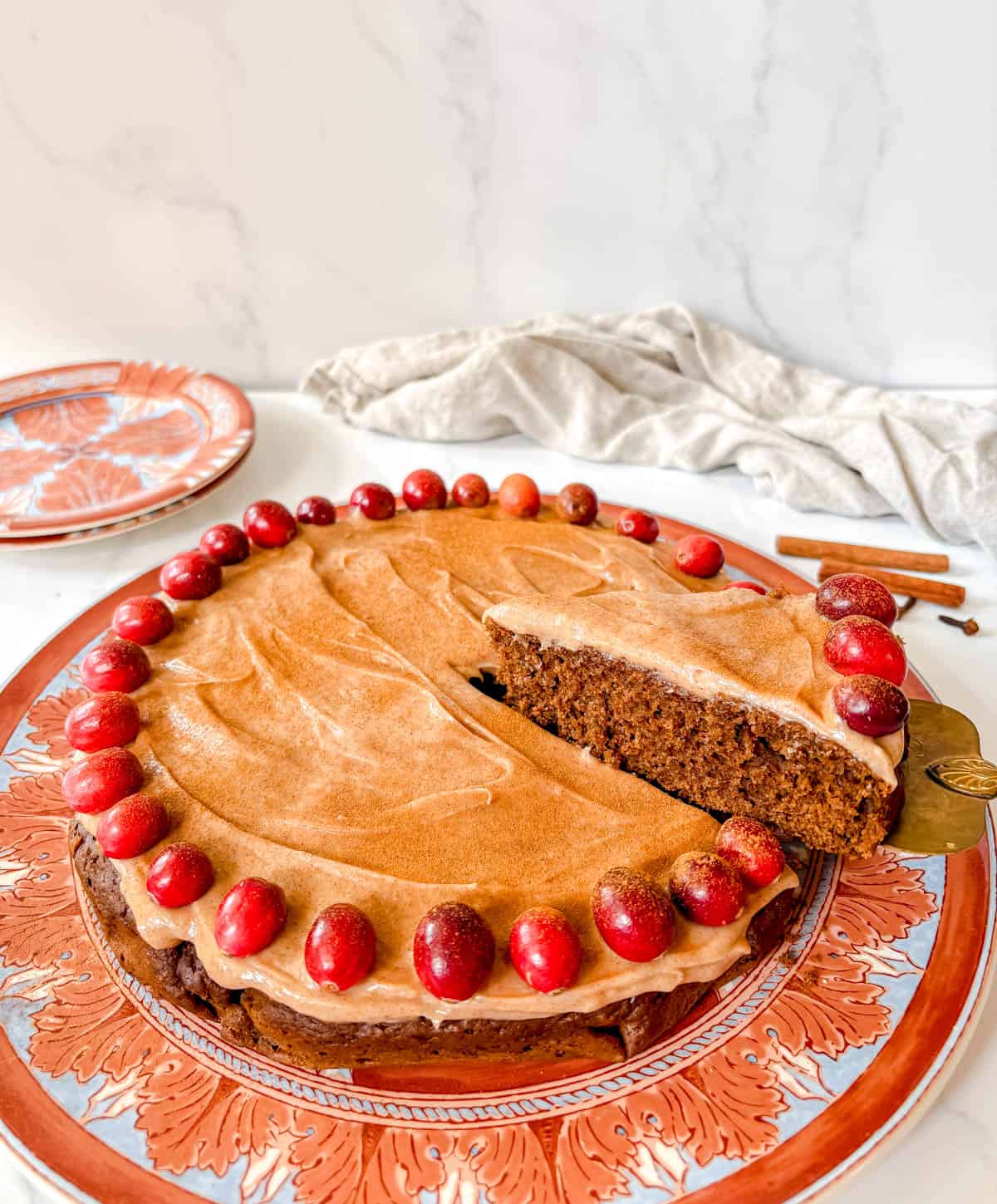 A slice of gingerbread cake with cream cheese frosting being served.