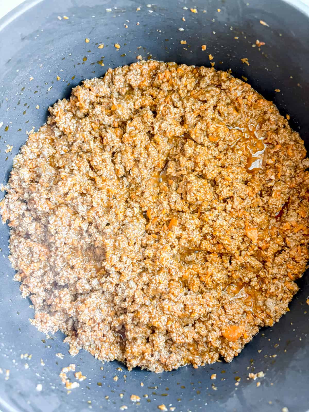 Browned ground beef in a pan.