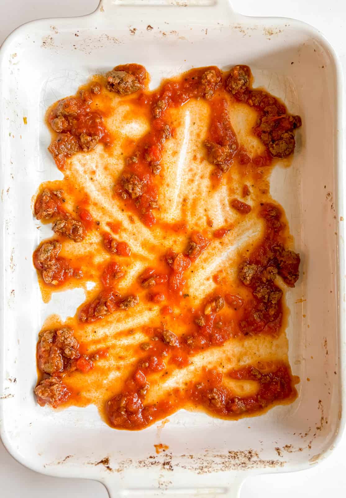Some meat sauce in the lasagna pan.