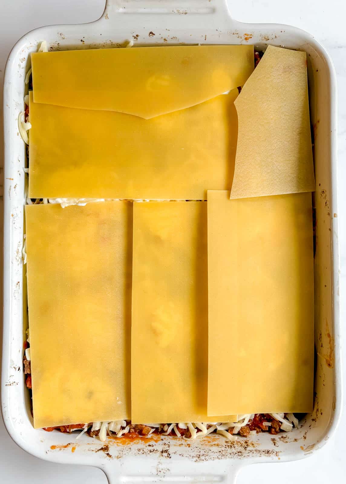 The last layer of no boil noodles added to the lasagna.
