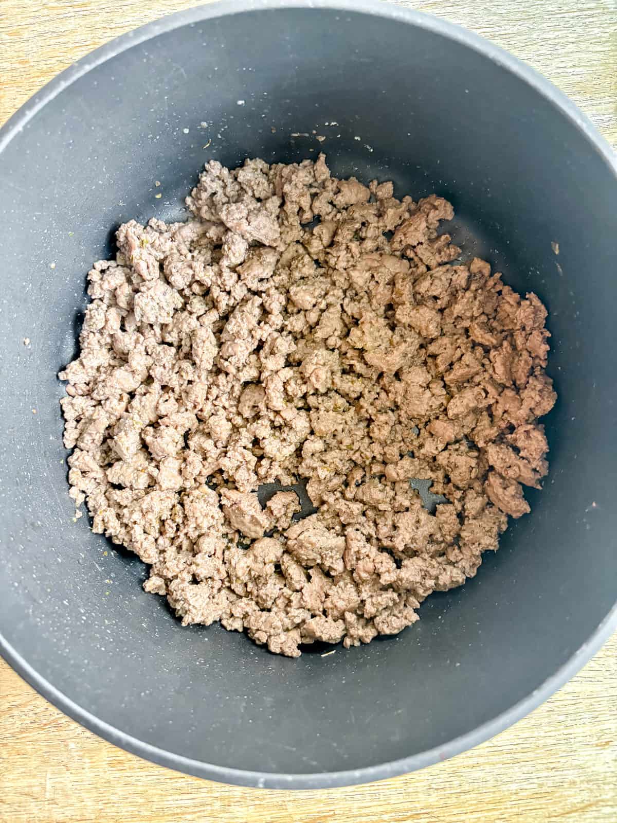 Ground beef browned in a pan.